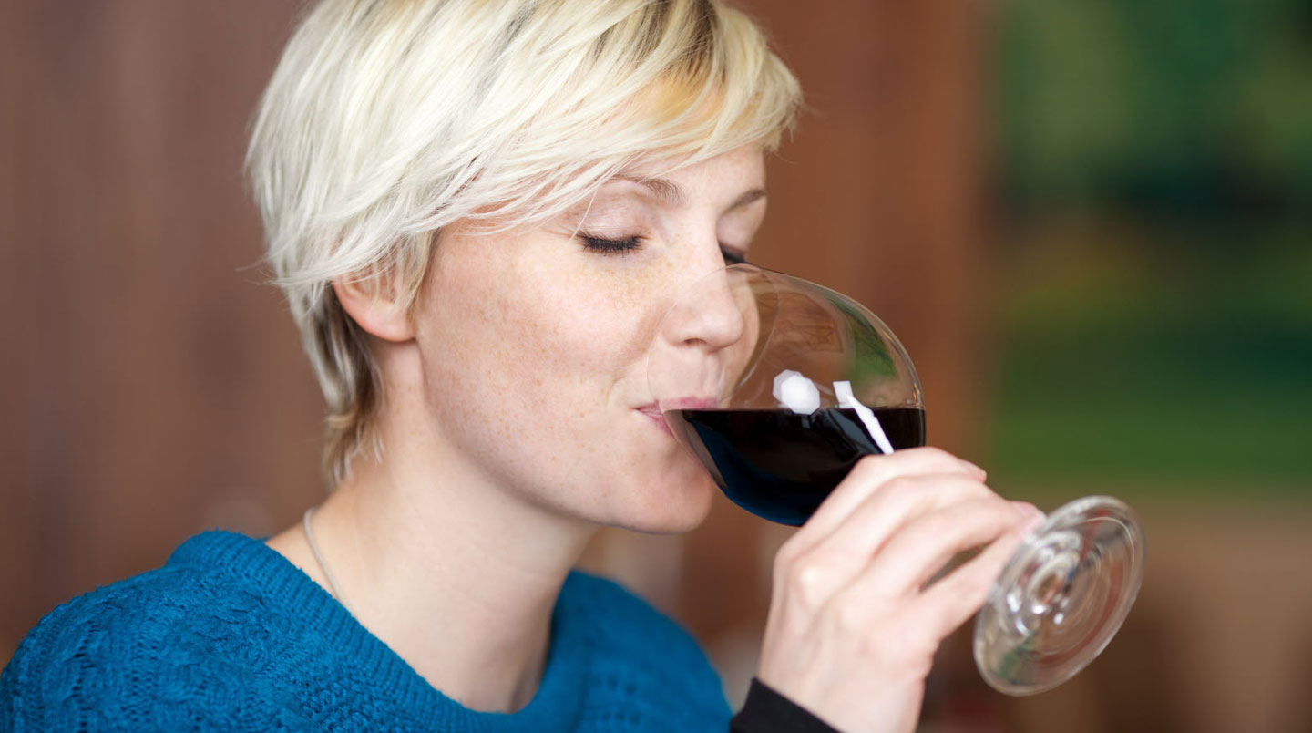 Deux verres à vin posés côte à côte sur une table en bois rustique, l'un visiblement plus fin que l'autre sous la lumière latérale